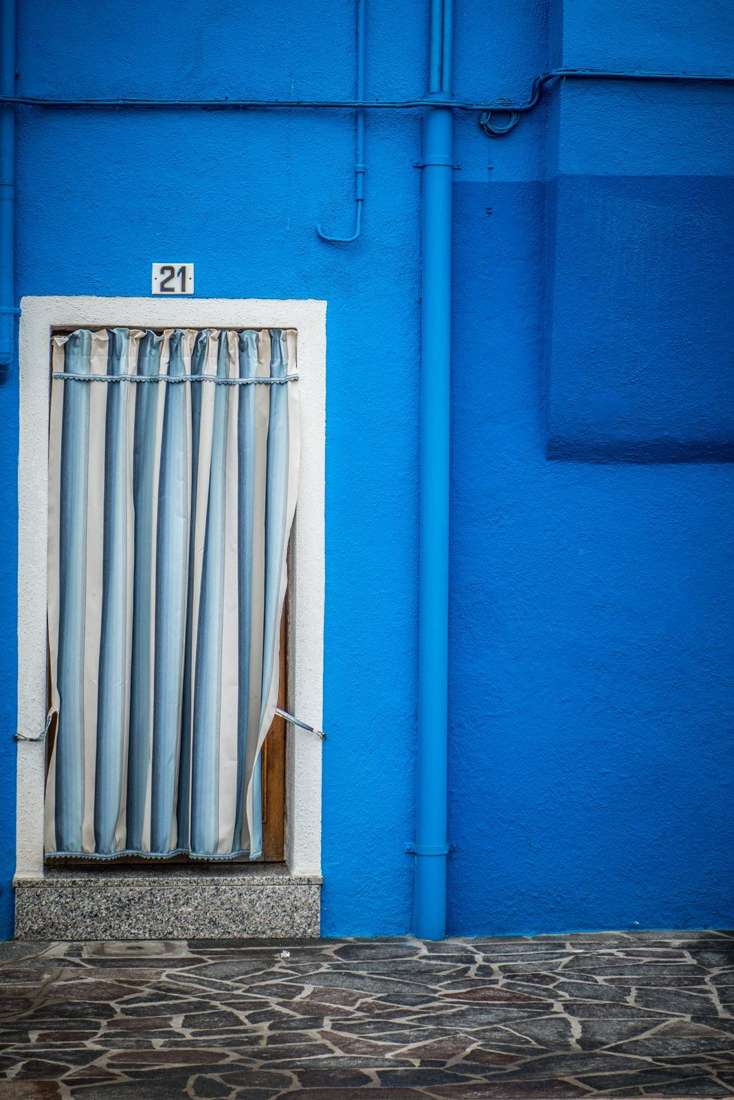 Striped curtain in a blue wall