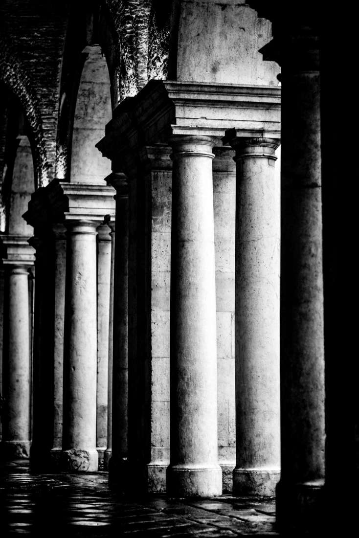 Stone columns in a dark arcade