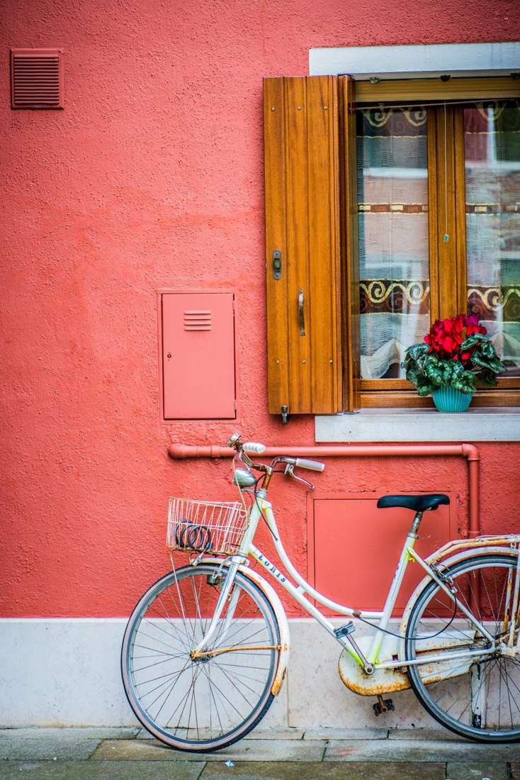 White bicycle on a coral wall