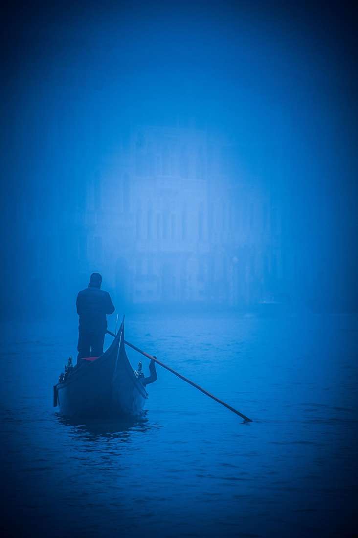 A gondolier standing in blue fog