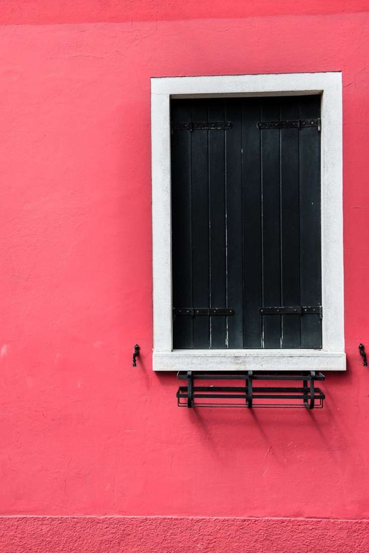 Black shutters on a pink wall