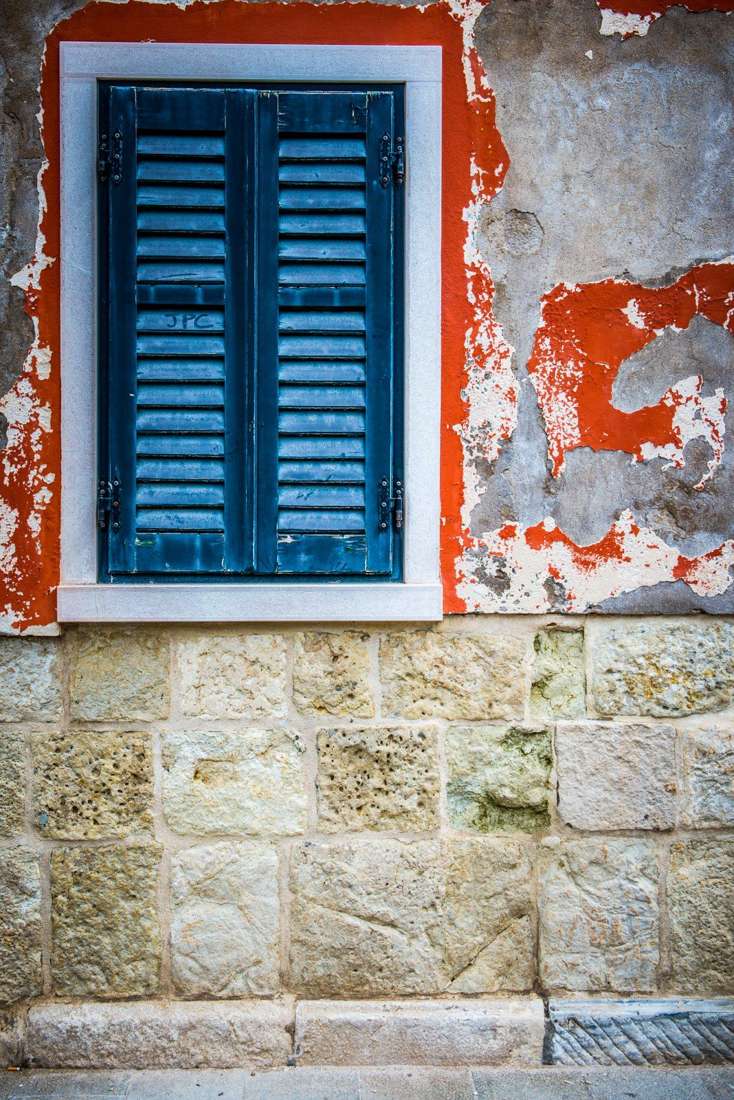 Blue shutter above a stone base